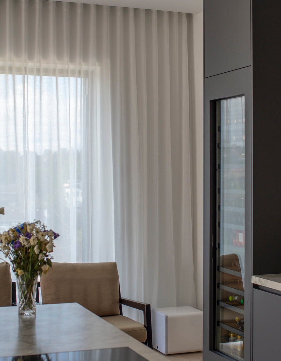 Vita skira gardiner i köksfönster