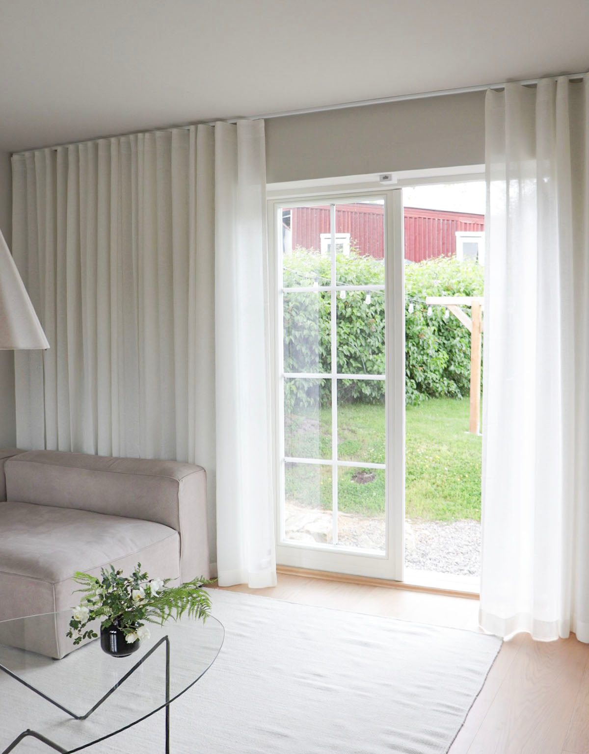 Breda vita gardiner i vardagsrum med altandörr