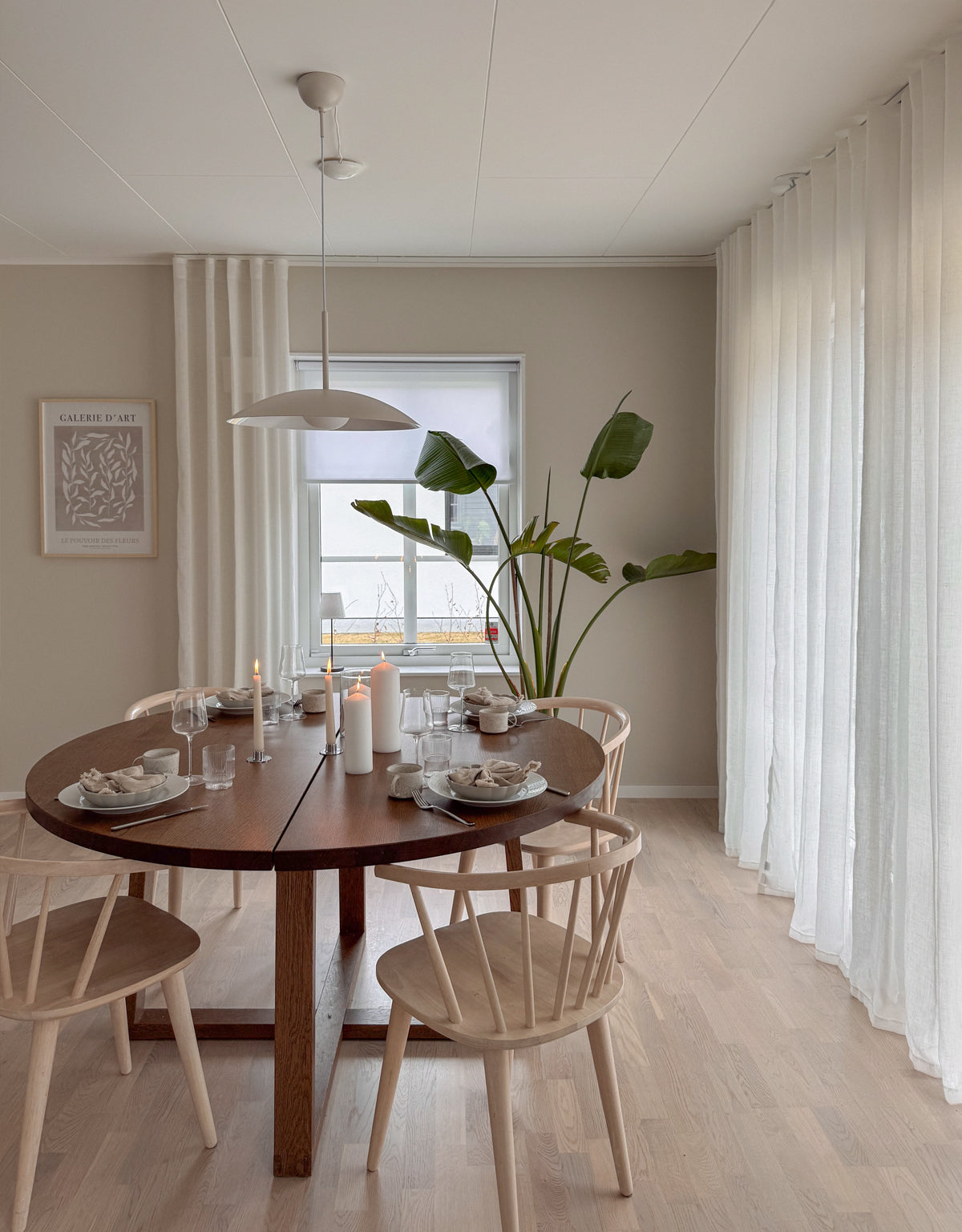 Vita skira gardiner tillsammans med vit avskärmande rullgardin
