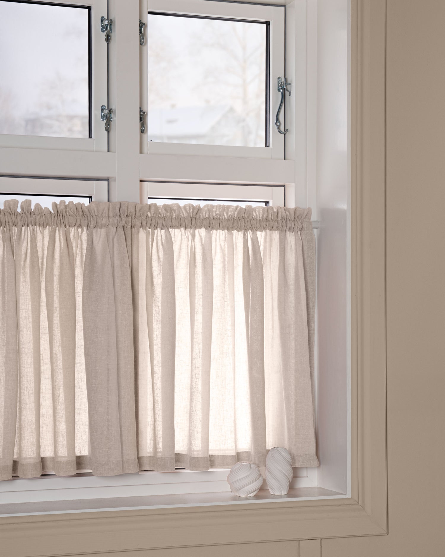 Beige cafégardin på spännstång i nisch