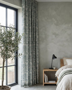Green room-darkening curtain with a botanical pattern