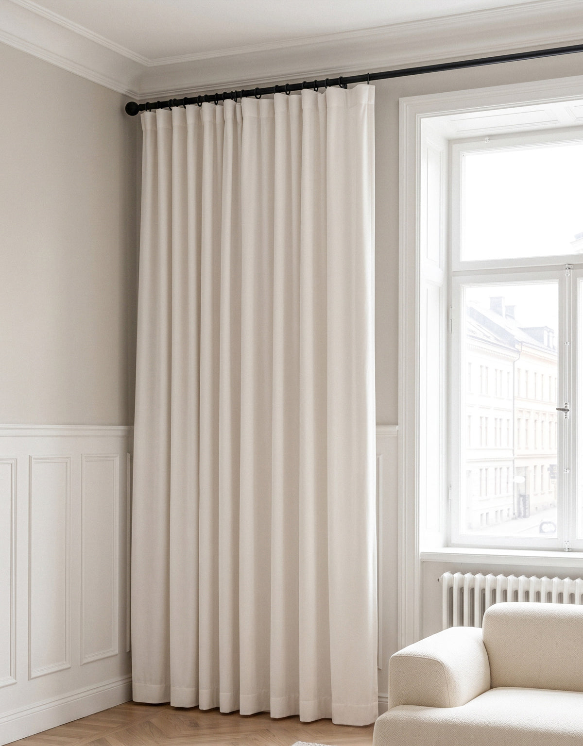 White curtain in velvet on a black curtain pole with curtain rings