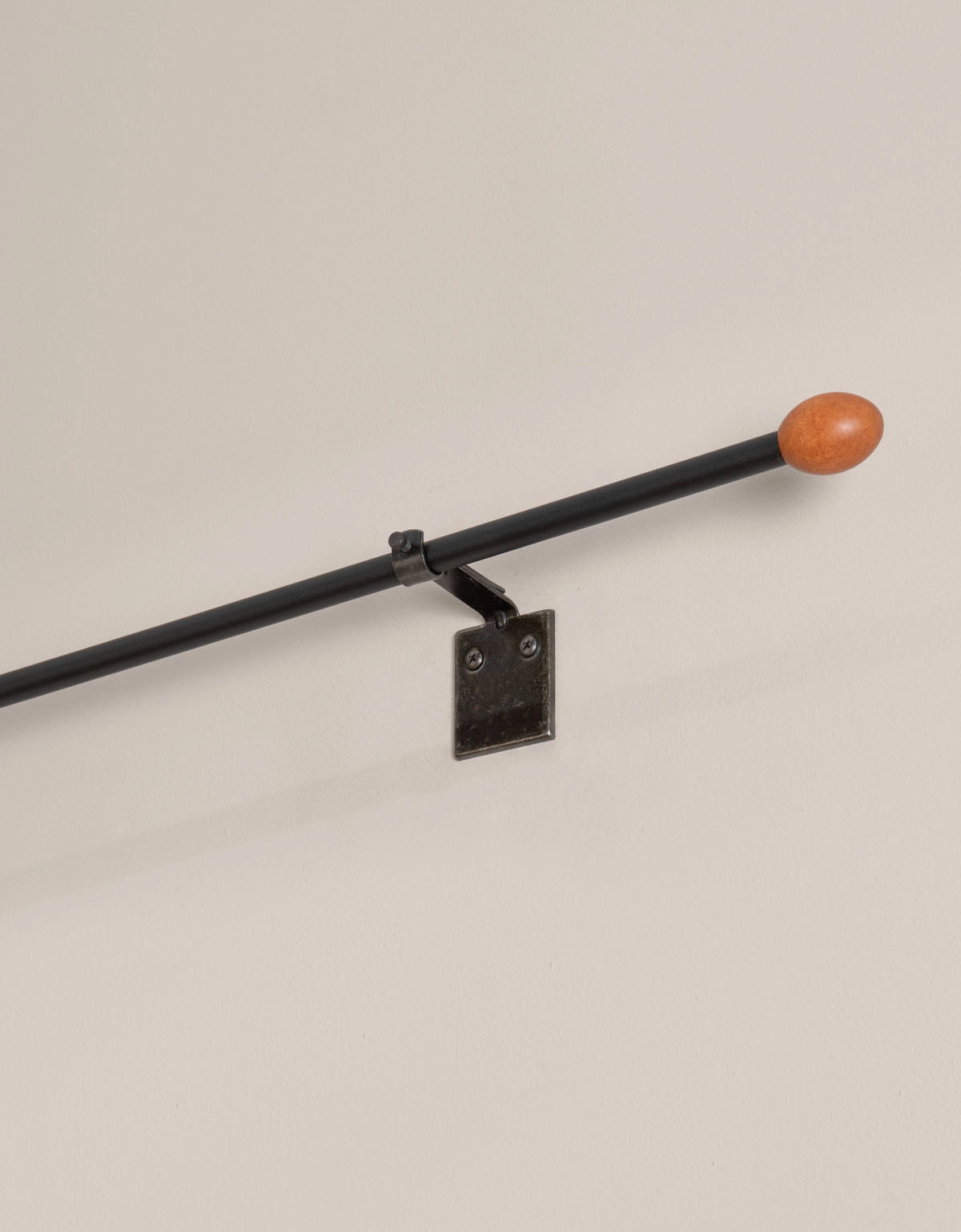 Svart gardinstång med oval knopp i trä